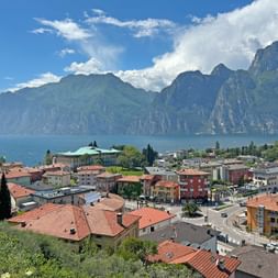 Blick von Nago aus auf ein Häusermeer, den Gardasee und die Berge