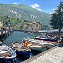 Der Hafen von Torbole am Gardasee mit Schiffen am Wasser.