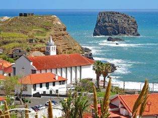 Blick auf die Kirche von Porto da Cruz, im Hintergrund ein frei stehender Felsen im Meer