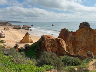 View over the beach to the stone towers of Porto Covo