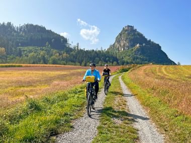 Hochosterwitz Castle Two cyclists on a country lane in front of Hochosterwitz Castle