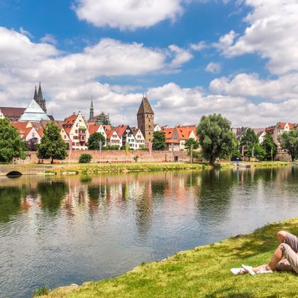 Cycling break by the river with a view of Ulm's old town and cathedral