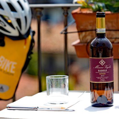 Rotwein; Eurobike Satteltasche und Fahrradhelm im Hintergrund