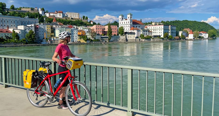 Cyclist during a stopover on a bridge with a view of Passau